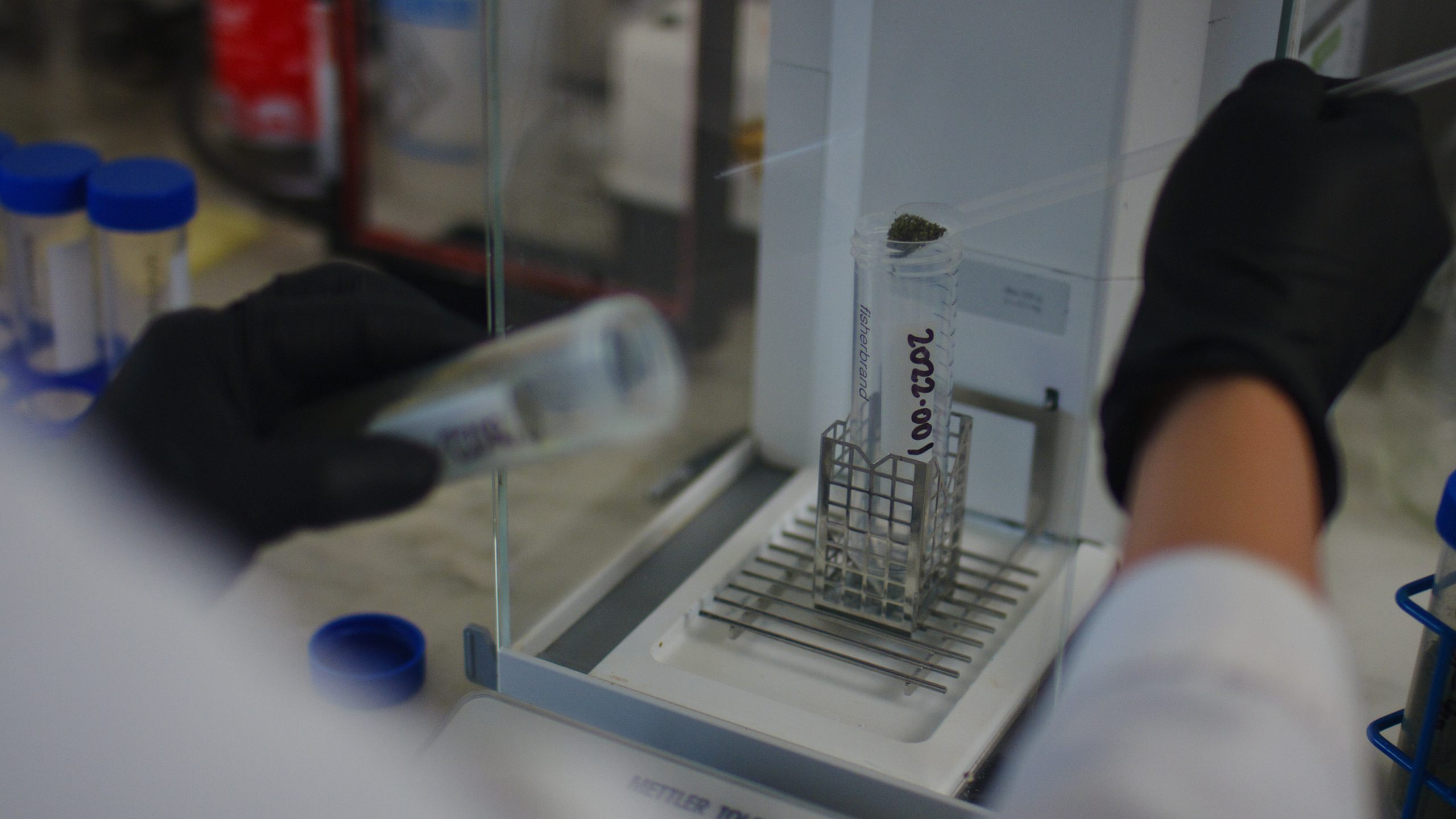 Microbiology Lab shows a lab tech scooping a material into a test tube