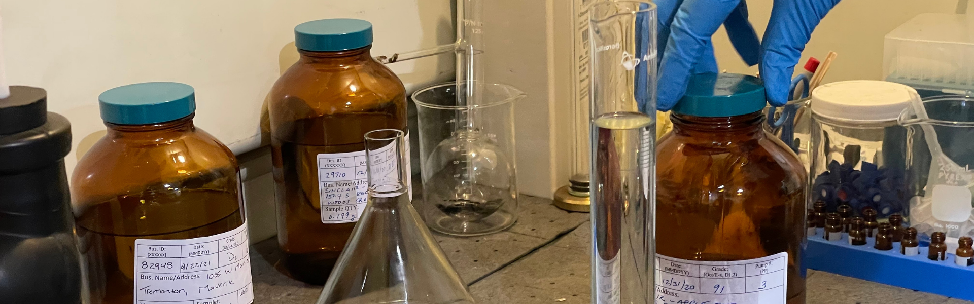 various science vials and beakers in multiple sizes and shapes, some with labels, some with no label